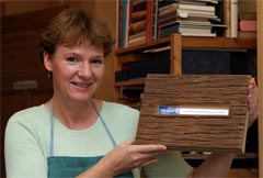 Christine Merkel-Köppchen shows a hand-crafted book cover made of wood